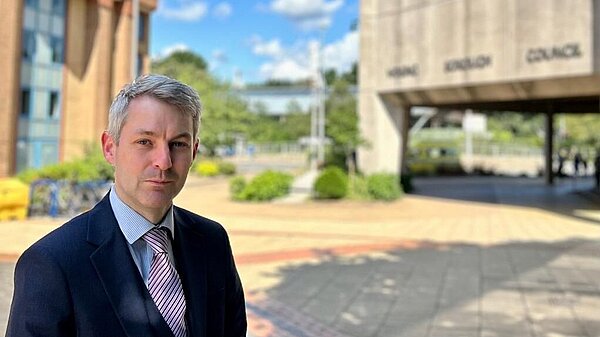 Will Forster stands outside the Woking Borough Council offices